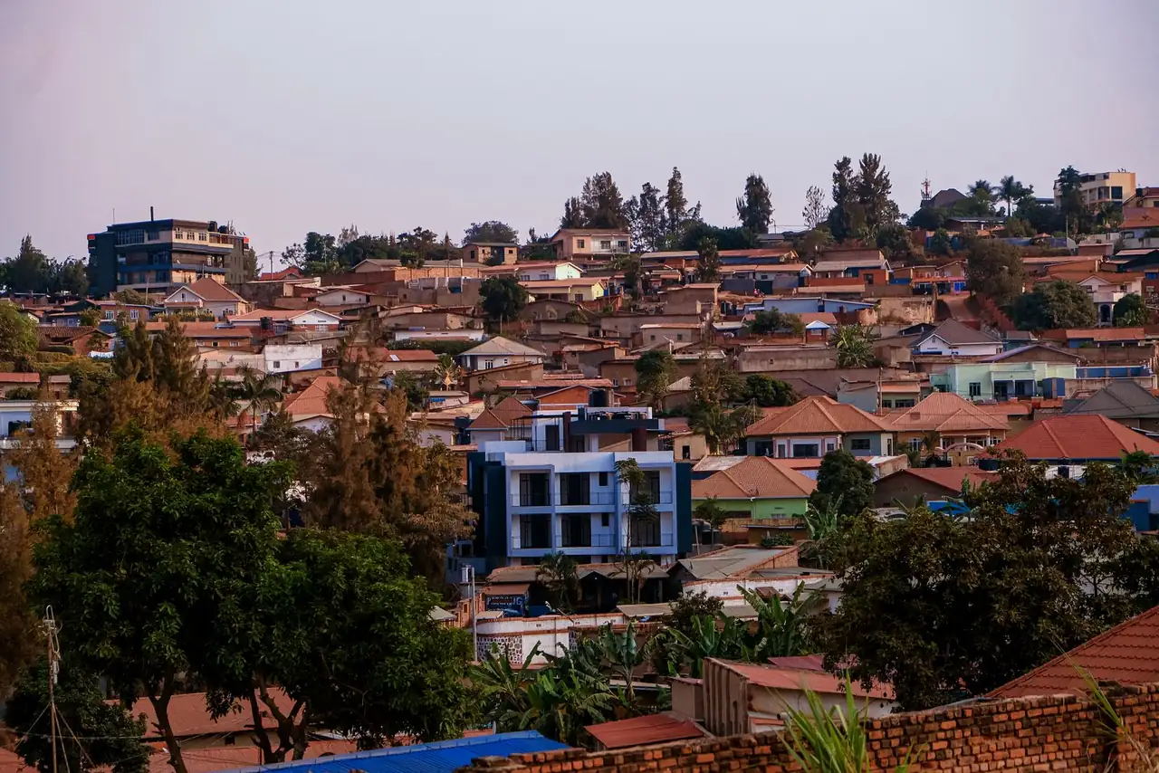 A vibrant panorama of Kigali's residential area showcasing architecture and greenery at sunset.