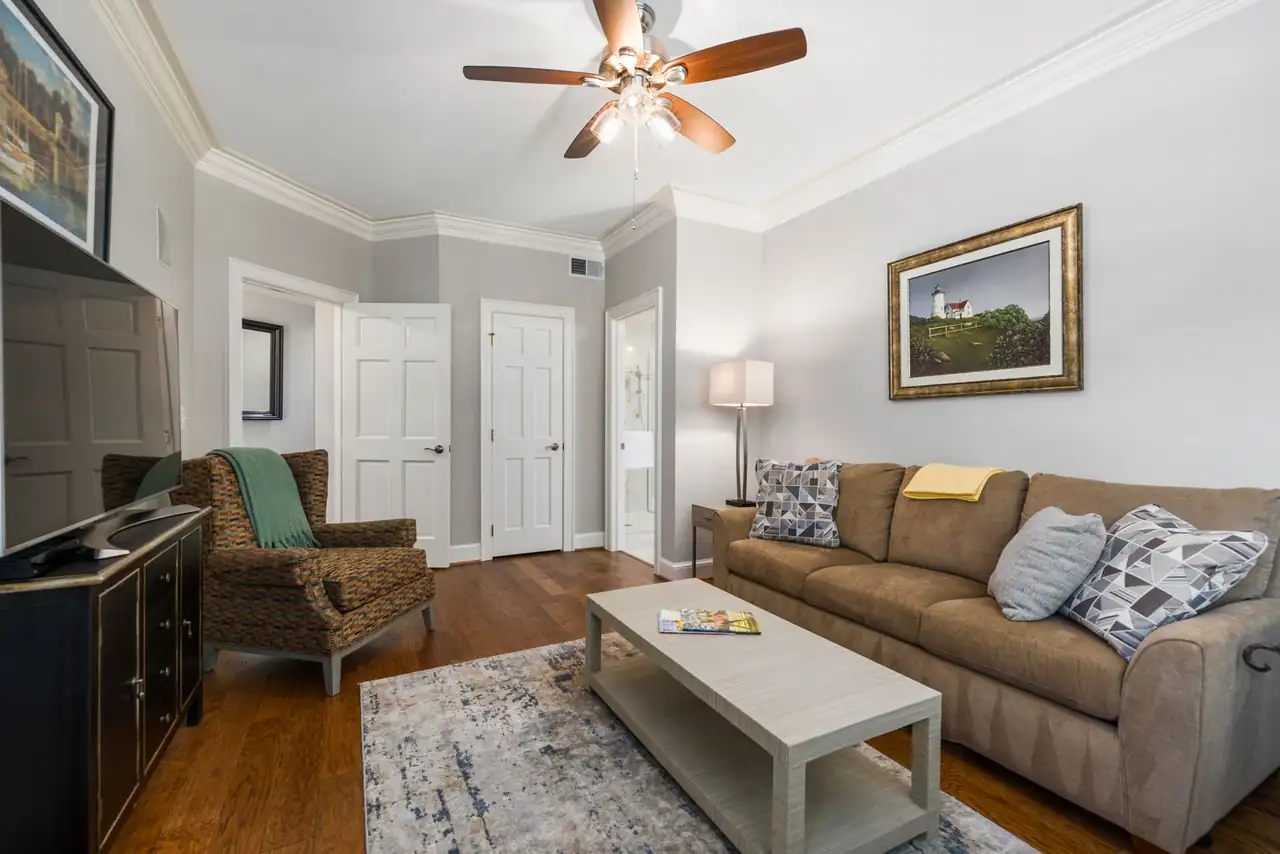 Cozy living room featuring a couch, armchair, and stylish decor with natural lighting.